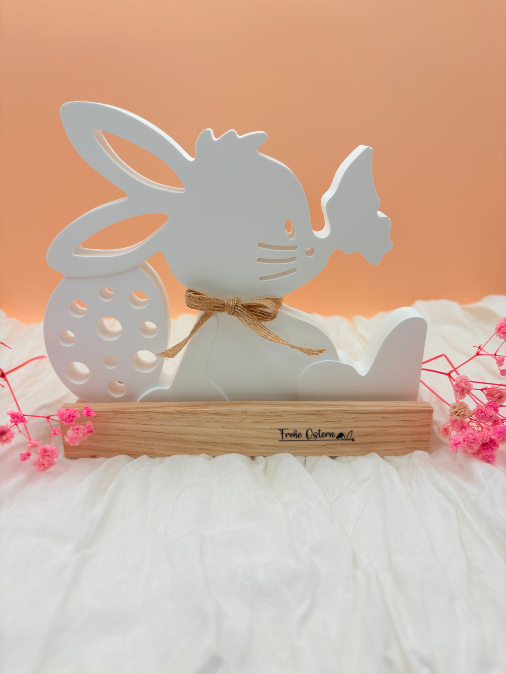 Osterhase sitzend auf Holzfuß