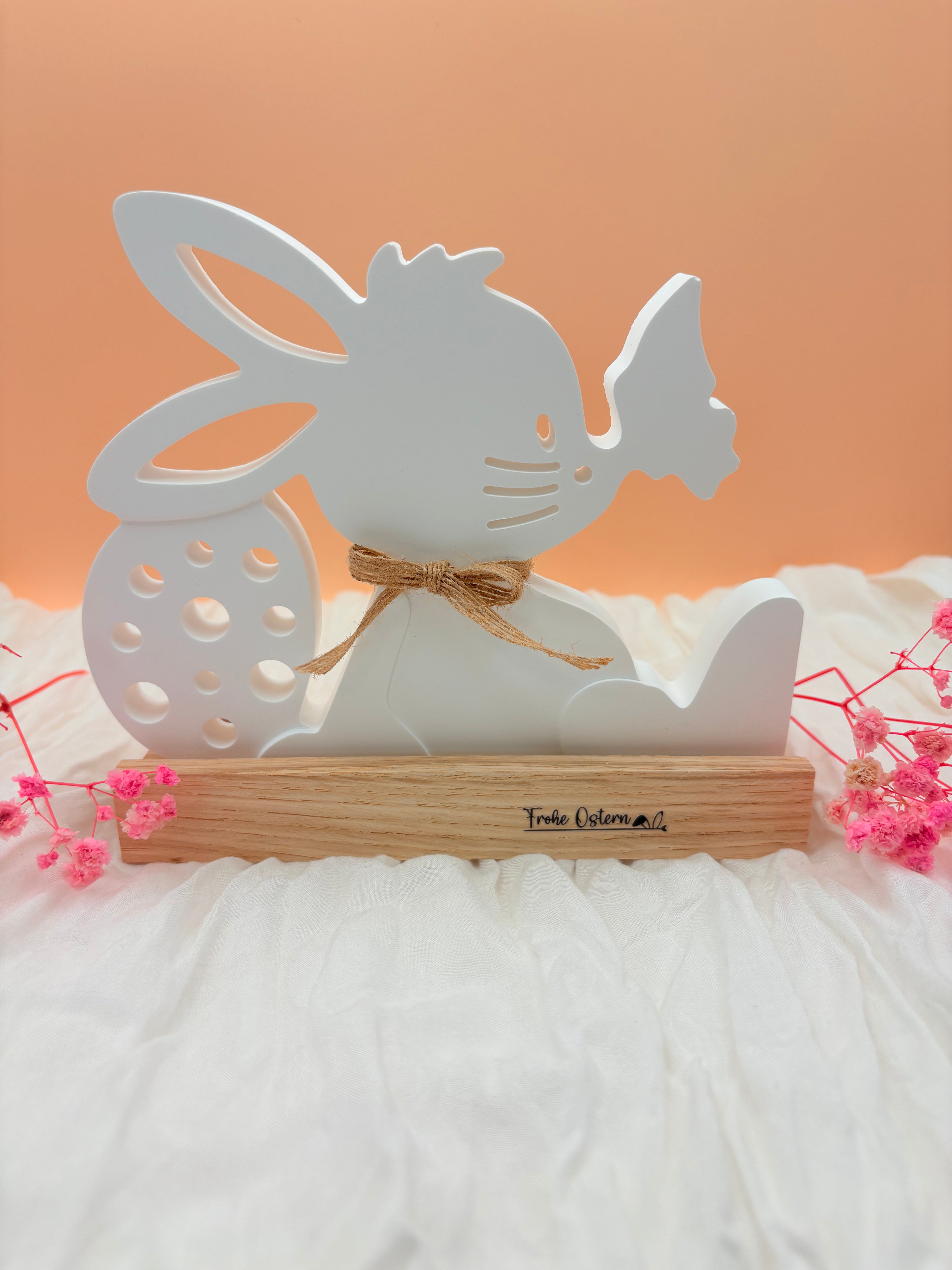 Osterhase sitzend auf Holzfuß