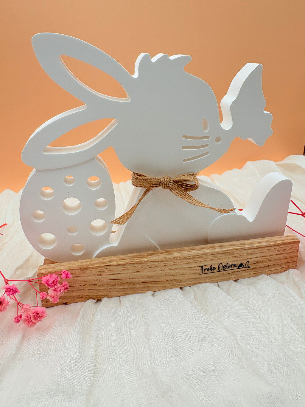 Osterhase sitzend auf Holzfuß